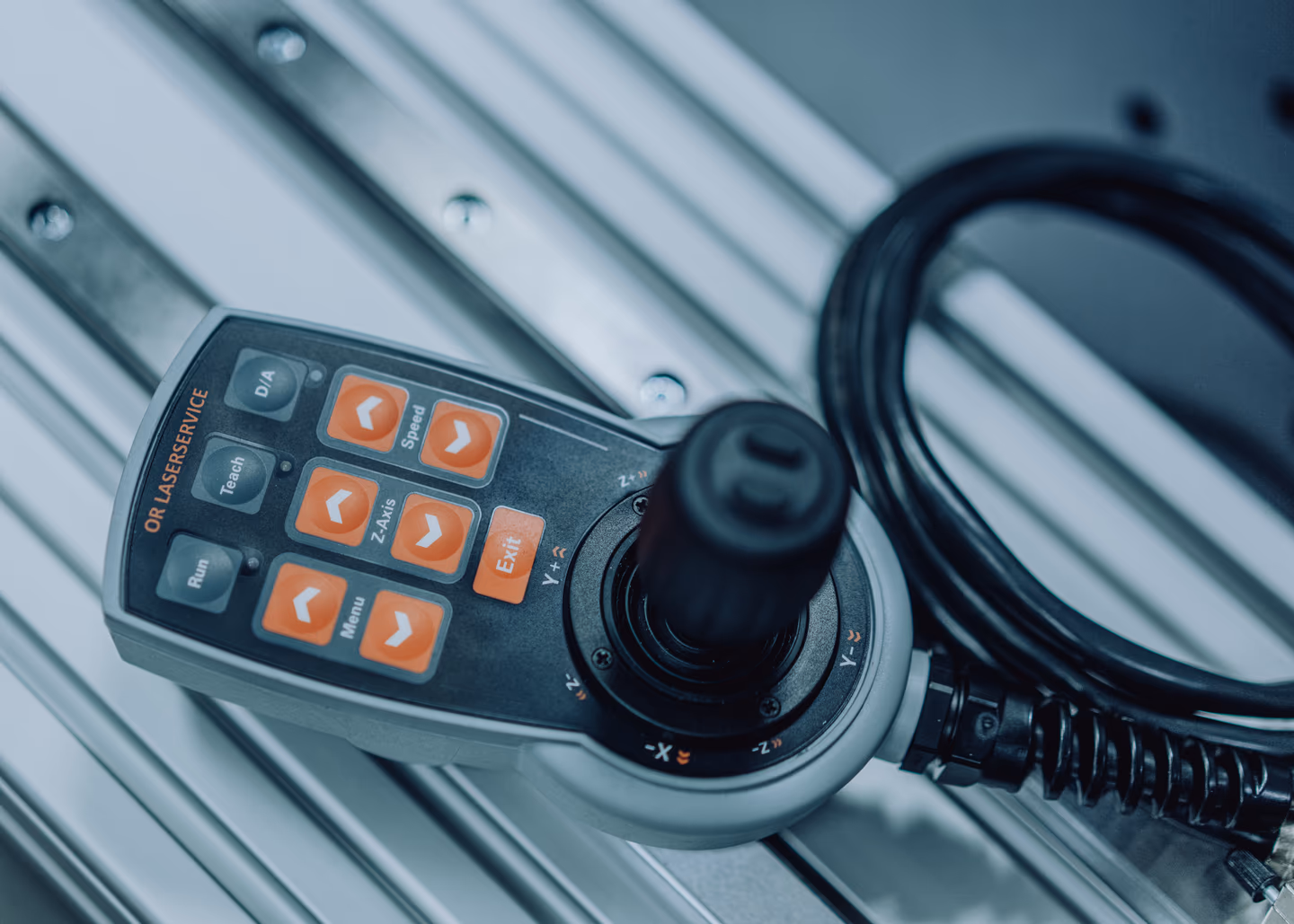 OR-Joystick-Bedieneinheit, beschriftete Tasten und Achsmarkierungen, Nahaufnahme.